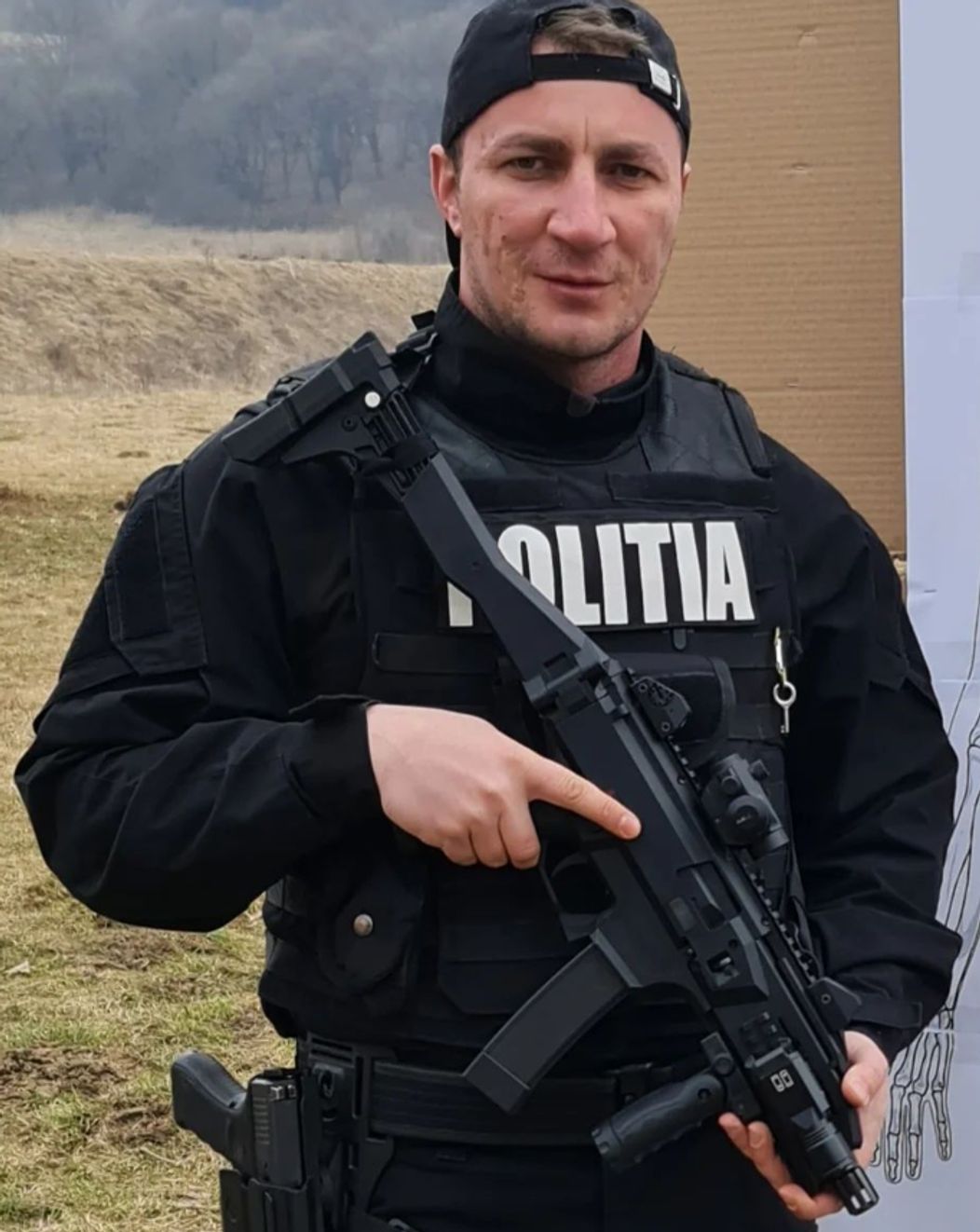 Marian Godină fotografiat în uniforma sa de intervenție, cu arma în mână