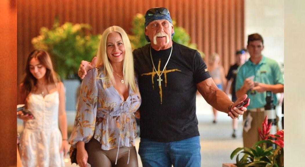 Hulk Hogan și Sky Daily zâmbesc la cameră atunci când un fotograf le face o fotografie