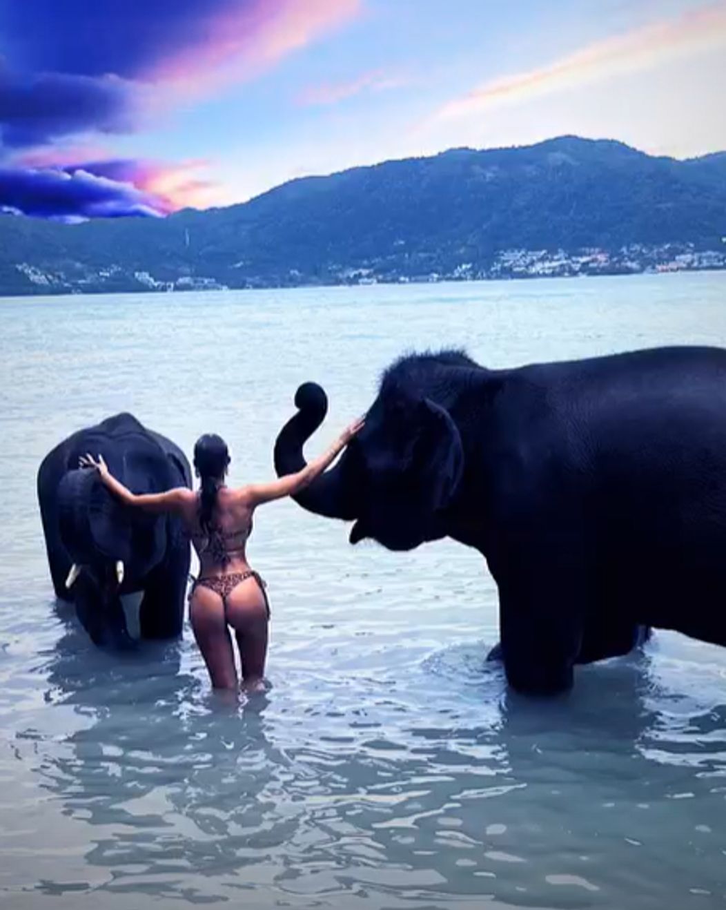Bianca Drăgușanu privește spre apus îmbrăcată în costum de baie, în timp ce se scaldă cu elefanții în vacanța din Thailanda 