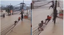 Imagini șocante din Thailanda: oamenii riscă tot, escaladând cablurile suspendate pentru a scăpa de inundații uriașe