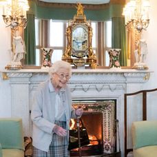 Regina Elisabeta a II-a zâmbește în timp ce e fotografiată în fața șemineului de la Palatul Balmoral