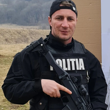 Marian Godină fotografiat în uniforma sa de intervenție, cu arma în mână