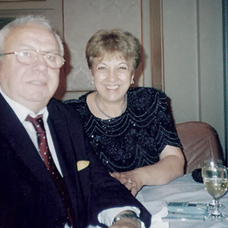 Alexandru Arșinel și soția lui, Marilena Arșinel, zâmbesc în timp ce sunt fotografiați la o petrecere