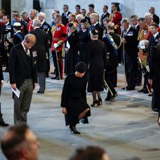 Meghan Markle se înclină în fața sicriului Reginei Elisabeta a II-a, de la Abația Westminster. Ducesa de Sussex este îmbrăcată într-o rochie neagră, care respectă doliul național