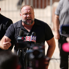Alex Jones vorbește pe un ton răstit în fața jurnaliștilor din  Waterbury, Connecticut, după decizia Curții Supreme din Waterbury care a hotărât că bărbatul trebuie să achite 49,5 milioane de dolari daune familiei unui băiat de 6 ani ucis în masacrul de l