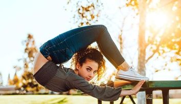 Trage la țintă cu picioarele, în timp ce stă în mâini. Tânăra care uimește lumea cu mobilitatea ei