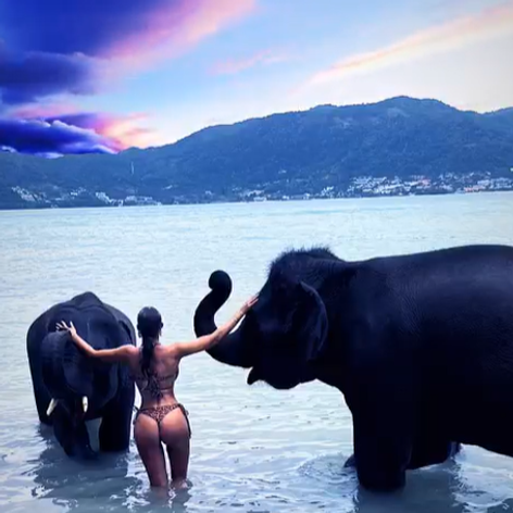 Bianca Drăgușanu privește spre apus îmbrăcată în costum de baie, în timp ce se scaldă cu elefanții în vacanța din Thailanda 