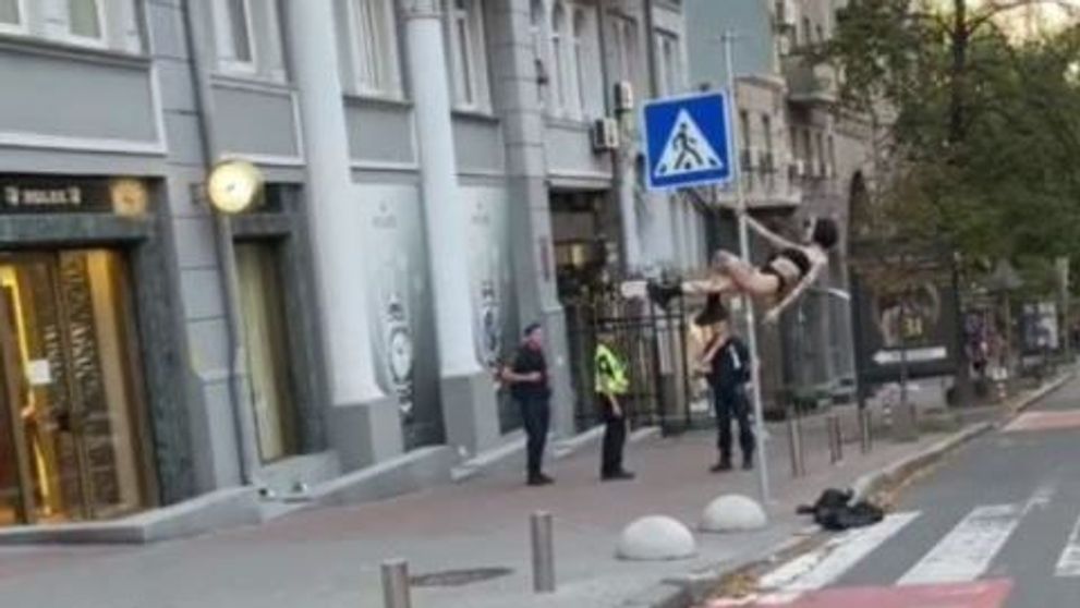 Un dans la bară mai puțin obișnuit. O tânără s-a urcat pe stâlpul unui indicator rutier ca să facă show