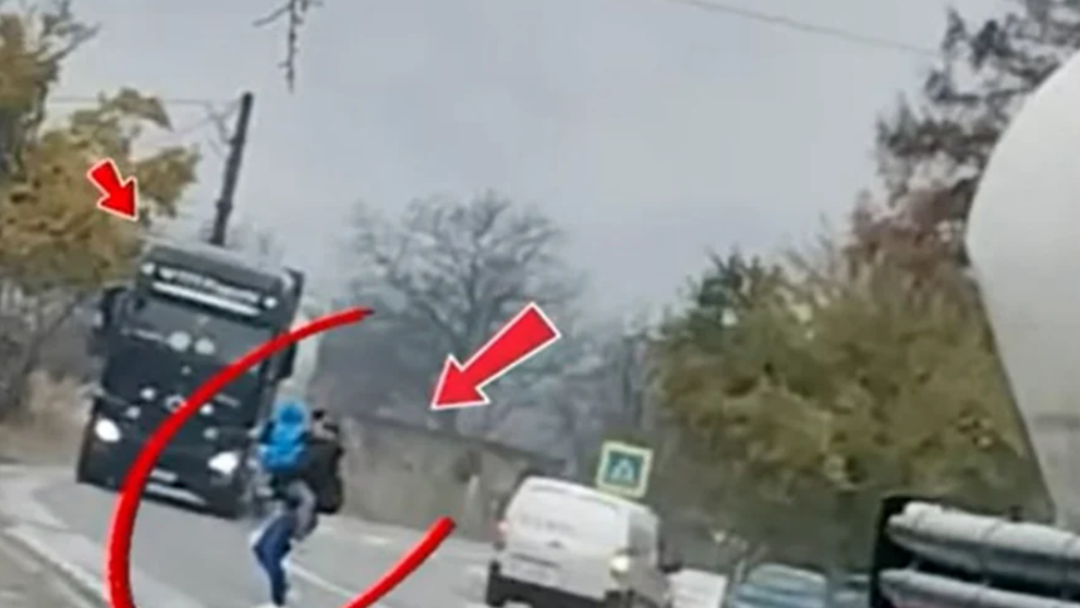 O mamă este fotografiată în timp ce trece cu copilul în brațe printre două TIR-uri. Trecerea de pietoni este la câțiva pași. Poliția: 11.582 de abateri ale pietonilor în doar o săptămână!