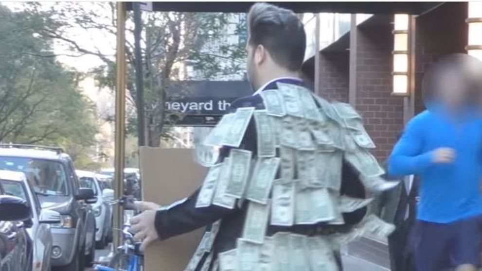 Si-a lipit bani pe sacou si i-a invitat pe trecatori sa ia atat cat le trebuie. Ce a urmat a ajuns viral - VIDEO